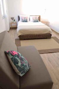 a bedroom with a bed and a couch with a pillow at Alojamento Charme in Bombarral