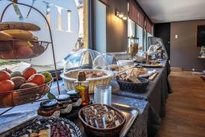 a buffet line with baskets of bread and other food at Park Hotel Airport in Charleroi +32 photos
