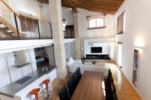 comedor y sala de estar con mesa y sillas en Dúplex tipo Loft con piscina, en Jerez de la Frontera