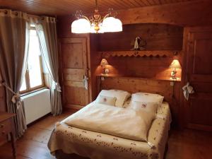 a bedroom with a bed and a chandelier at Le Bellevue in Giron