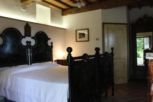 ein Schlafzimmer mit einem großen schwarzen Bett mit weißer Bettwäsche in der Unterkunft Camere Alabastro Fontesettimena in Volterra