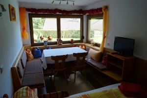 a room with a table and chairs and a tv at Appartements Gerhard in Telfes im Stubai