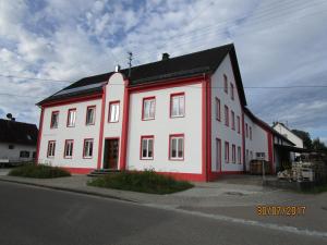 a large white building with a black roof at Ferienwohnung Rosa in Obergessertshausen