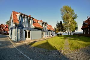 a building with a grass yard next to a house at Laiko marios in Preila