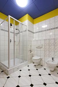 a white bathroom with a shower and a toilet at Casino & Hotel Eldorado in Česká Kubice