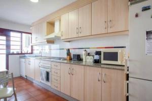 a kitchen with wooden cabinets and a white refrigerator at Apartamento Cerca De Valencia in Riba-Roja De Turia