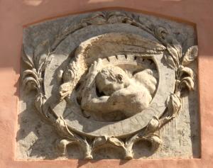 une statue en pierre d'un lion sur le côté d'un bâtiment dans l'établissement Tenuta di Corsano, à Monteroni dʼArbia