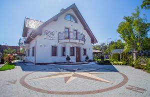 a large white house with a circle in the driveway at Lilu Apartamenty in Dziwnów