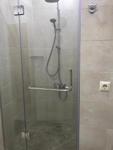 a shower stall with a glass door with a shower at Batumi Porta Tower 1611 in Batumi