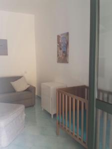 - un salon avec un canapé et un lit bébé dans l'établissement Isca della Contessa, à Palinuro