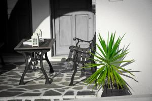 a bench and a table and a plant in front of a door at Angelos Rooms in Irakleia