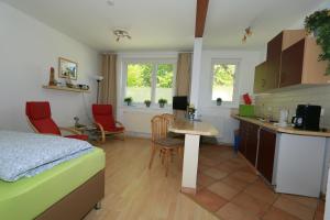 a kitchen and a bedroom with a bed and a table at Feriendomizil Achtern Öwer in Lohme