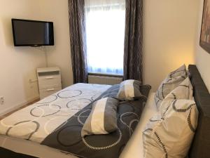 Un dormitorio con una cama con televisión y una ventana. en Haus am Mühlbach, en Boppard