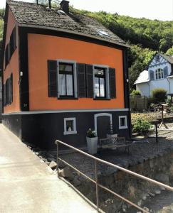 ein kleines Haus mit orangefarbener und schwarzer Fassade in der Unterkunft Haus am Mühlbach in Boppard