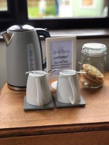 a counter with a coffee maker and two mugs at The Earsdon Annexe in North Walsham