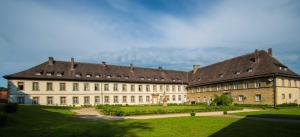 un grand bâtiment avec un toit brun dans l'établissement Hotel Schloß Gehrden, à Gehrden