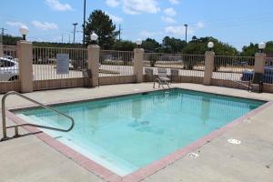 una piscina en un patio con una valla en Highland Inn Denham Springs Baton Rouge East, en Denham Springs