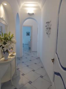 un corridoio con pareti bianche e pavimento piastrellato di Casa Lara 2 a Positano
