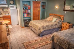 a bedroom with two beds and a kitchen with a stove at Holiday Lodge on Canyon Lake in Canyon Lake