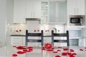 a kitchen with a table with red roses on it at "Ventana del Guadalquivir " in Baeza