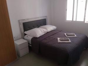甘迪亞的住宿－Apartamento "Pedro" 250 m de la playa，一间卧室配有一张床,上面有两条毛巾