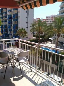 甘迪亞的住宿－Apartamento "Pedro" 250 m de la playa，一个带桌椅的阳台和一个游泳池