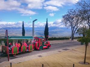 a red and green train with people riding at "Ventana del Guadalquivir " in Baeza +14 photos
