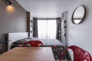 um quarto com uma cama, uma mesa e um espelho em Studio Air d'été em Roquebrune-Cap-Martin