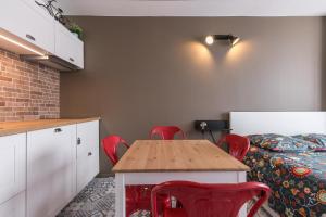 um quarto com uma mesa e cadeiras vermelhas e uma cama em Studio Air d'été em Roquebrune-Cap-Martin