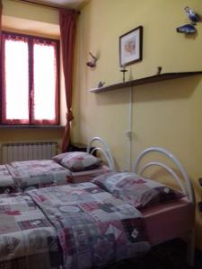 two beds in a bedroom with two birds on the wall at Eli's House in Bolzano Novarese
