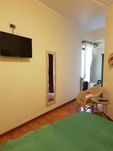 1 dormitorio con TV en la pared y espejo en B&B La Piazzetta en Paola
