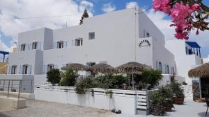 a white building with potted plants in front of it at Kamarela Studios in Kamari