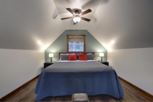 a bedroom with a blue bed with a ceiling fan at Bambury's Hillside Chalets in Rocky Harbour