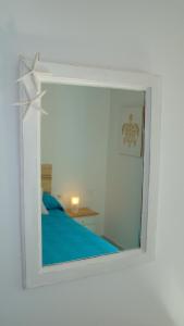 a mirror in a white room with a bed at The Beach House in El Médano