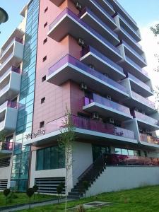 a tall pink building with a tree in front of it at Apartament Sebastian - Vila Sophia 3 Mamaia in Mamaia