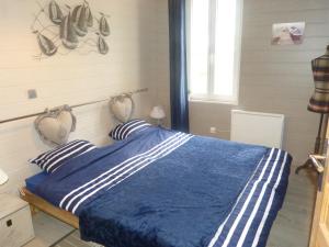 a bedroom with a bed with a blue comforter at Chez Isa in Yport
