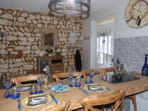 a wooden table with chairs and a clock on the wall at Chez Isa in Yport