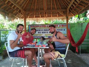 a group of three men sitting at a table at Pelangi Homestay Bungalow Gili gede in Sekotong +68 photos