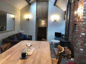 a dining room with a wooden table and a brick wall at Tracey's Farmhouse Cottage in Belfast
