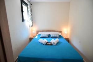 a bedroom with a blue bed with towels on it at Searockhouse in Paleo Tsifliki