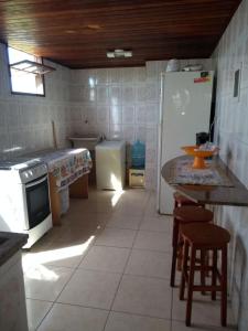 a kitchen with a refrigerator and a table and chairs at Apartamento de temporada in Rio das Ostras