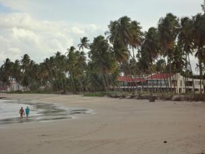 zwei Personen stehen am Strand mit Palmen in der Unterkunft Casa Praia dos Carneiros in Tamandaré