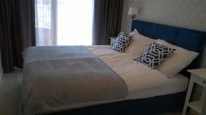 グダニスクにあるApartament Sea & Relaxのベッド(青いヘッドボード、枕付)