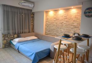 a bedroom with a bed and a table with stools at Theoni's Seaside Apartment in Kalamata