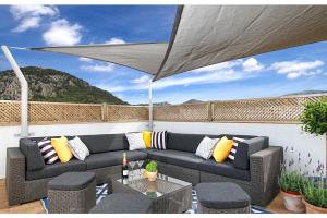 a patio with a couch and a table and an umbrella at Casa Hugo in Pollença