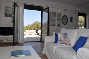 Nefeli Villas في خيرسونيسوس: غرفة معيشة مع أريكة بيضاء وطاولة