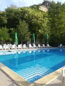 a large swimming pool with chairs and umbrellas at Elli Greco Hotel in Melnik