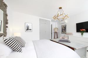 ポリェンサにあるCasa Hugoの白いベッドルーム(ベッド1台、シャンデリア付)