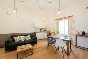 ein Wohnzimmer mit einem Sofa und einem Tisch in der Unterkunft Ortigia Suite - Giudecca in Syrakus