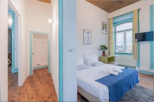 um quarto com uma cama com um cobertor azul em C&O Guest House Lisbon em Lisboa